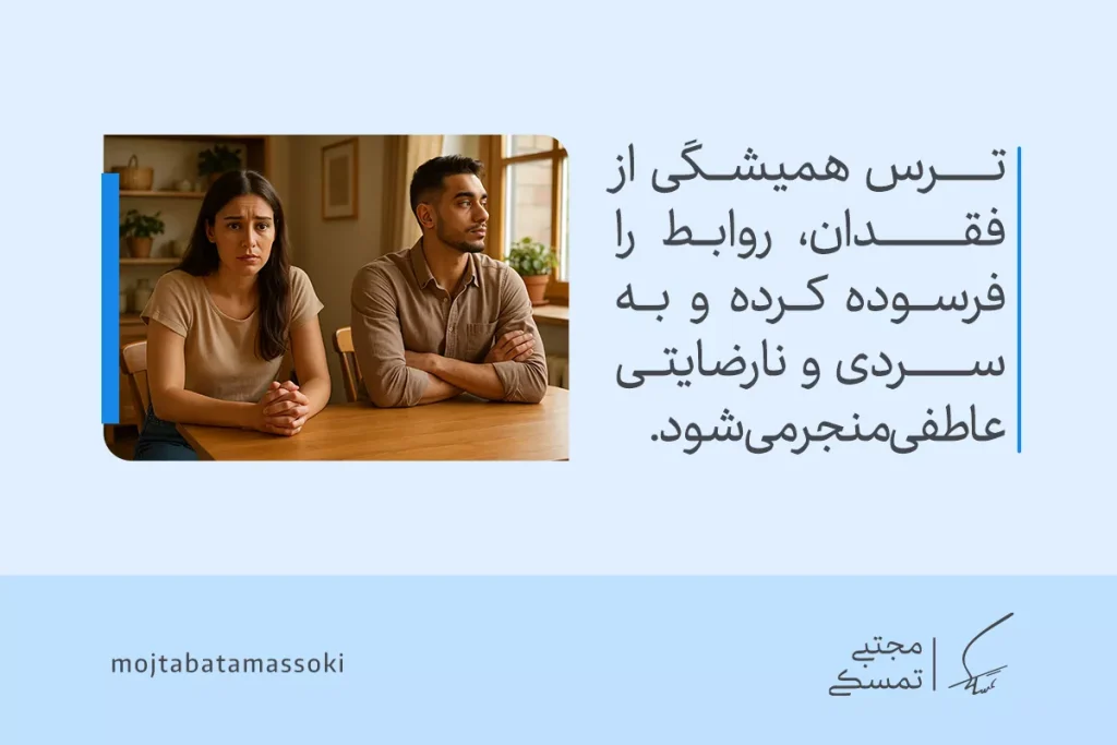 زن ناراحت و مرد بی‌تفاوت پشت میز نشسته‌اند و نشانه‌های سردی رابطه ناشی از ترس از دست دادن عزیزان را نشان می‌دهند.