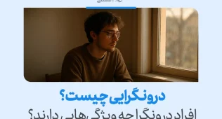تصویر مردی آرام کنار پنجره که در تفکر عمیق فرو رفته و فضای خلوت و تأمل‌محور درونگرایی را در رفتار روزمره نشان می‌دهد.