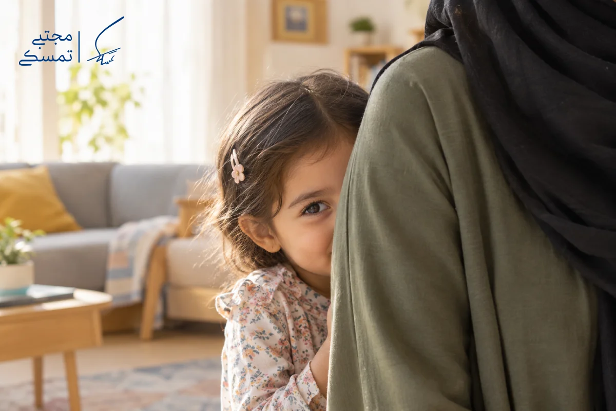 کودک خجالتی که پشت مادرش پنهان شده است